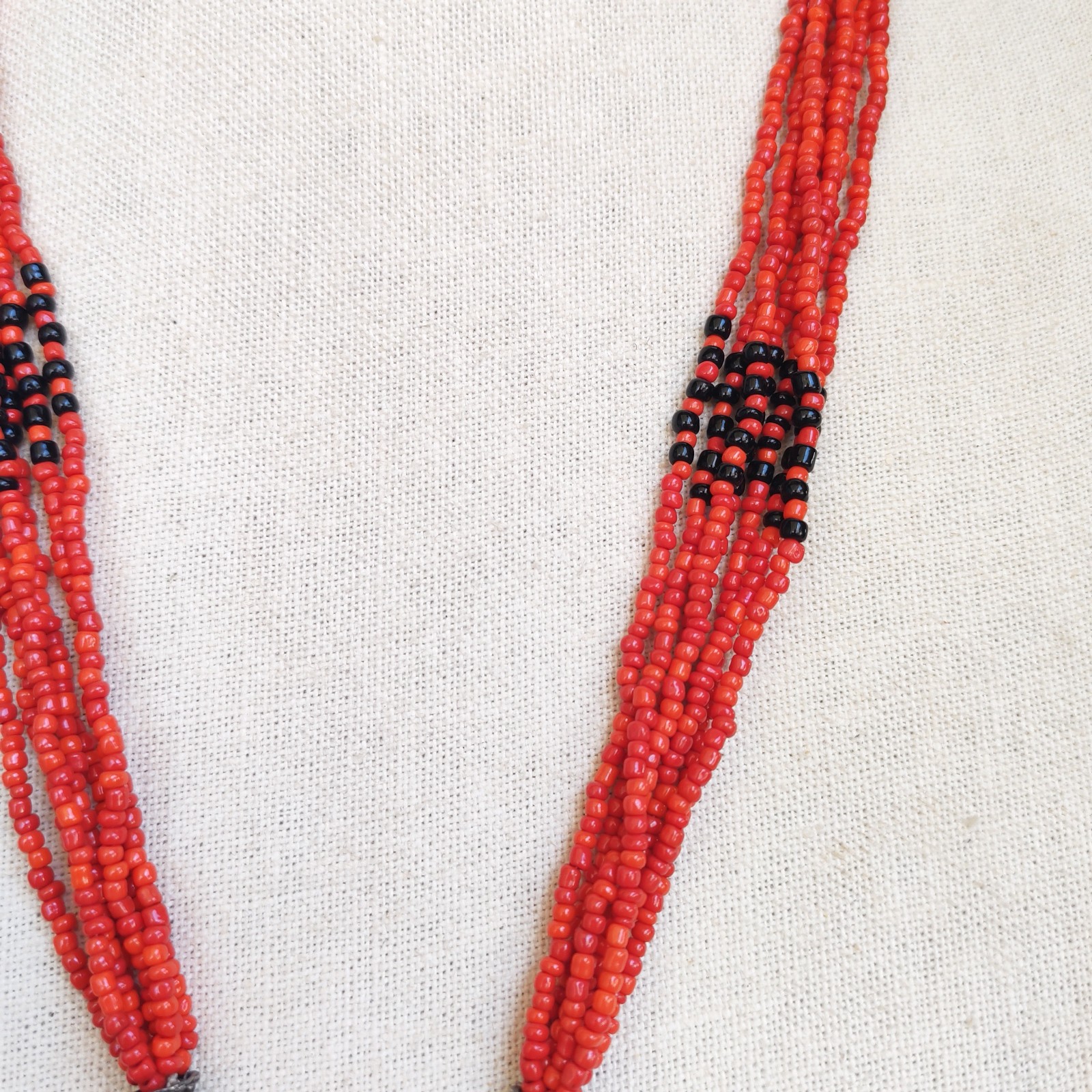 Vintage Red Faux Coral Beaded Necklace with Silver Tone Pendant and Tassel detail photograph