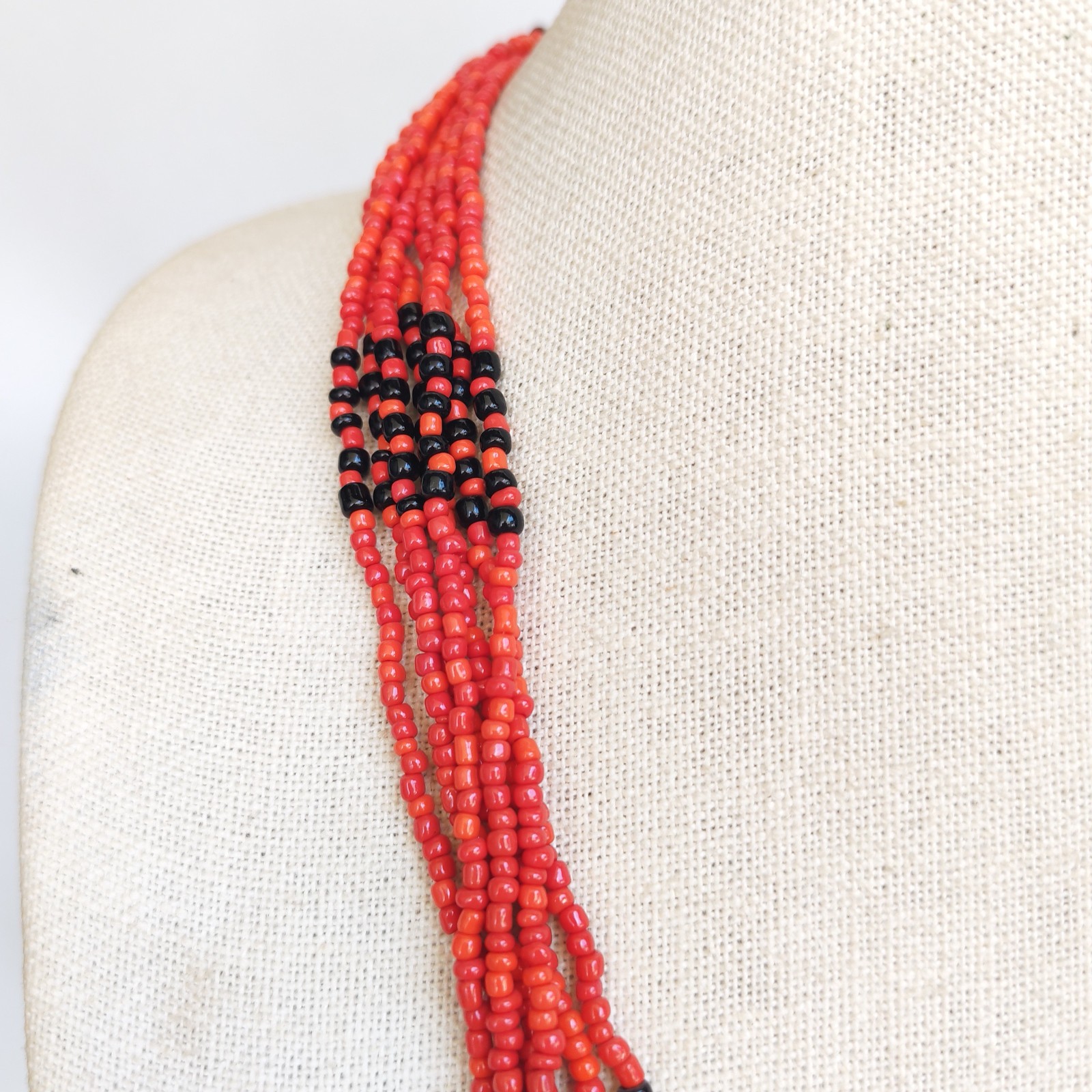 Vintage Red Faux Coral Beaded Necklace with Silver Tone Pendant and Tassel detail photograph
