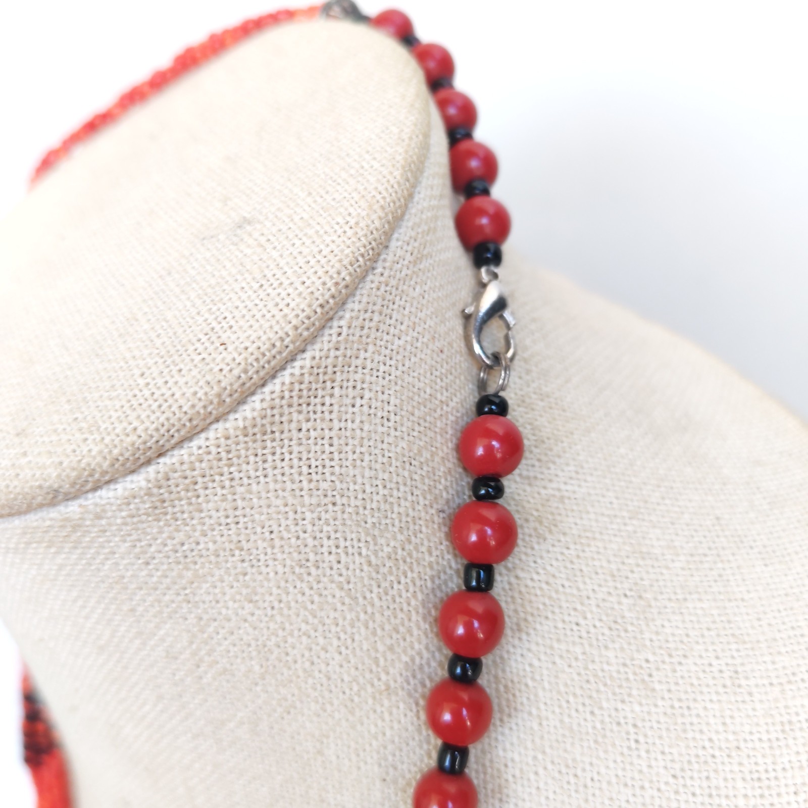 Vintage Red Faux Coral Beaded Necklace with Silver Tone Pendant and Tassel detail photograph