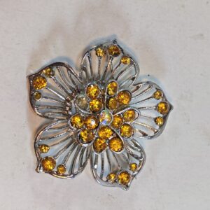 floral-shaped brooch featuring yellow or orange rhinestones 1.5"