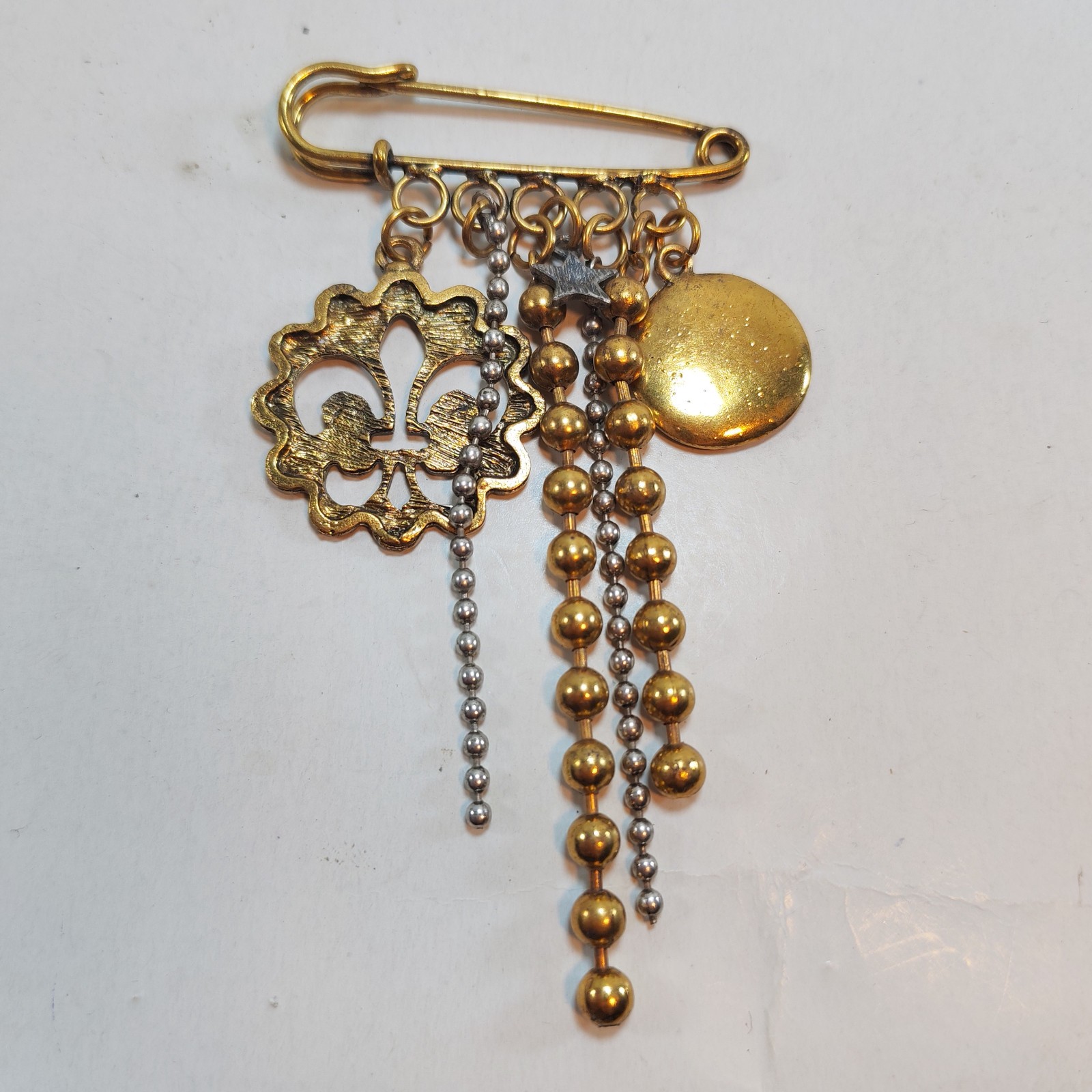 Vintage Brass safety pin brooch dangling scouts logo 3 detail photograph